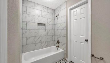 Small Bathroom with Marble Tub Tile Surrounds and Vintage Floor