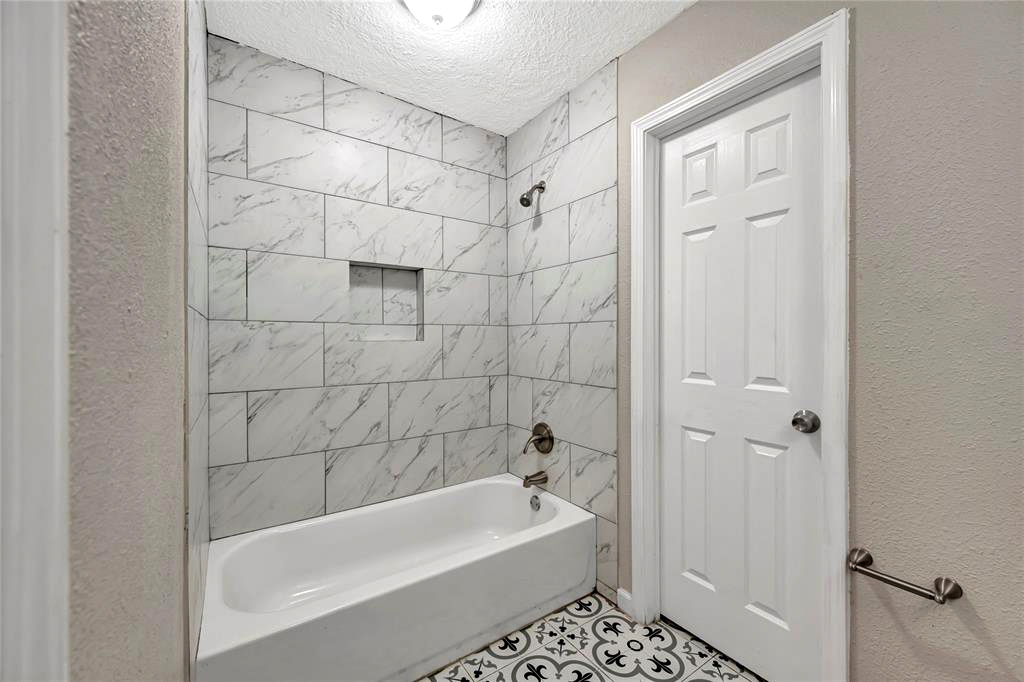 Small Bathroom with Marble Tub Tile Surrounds and Vintage Floor 
